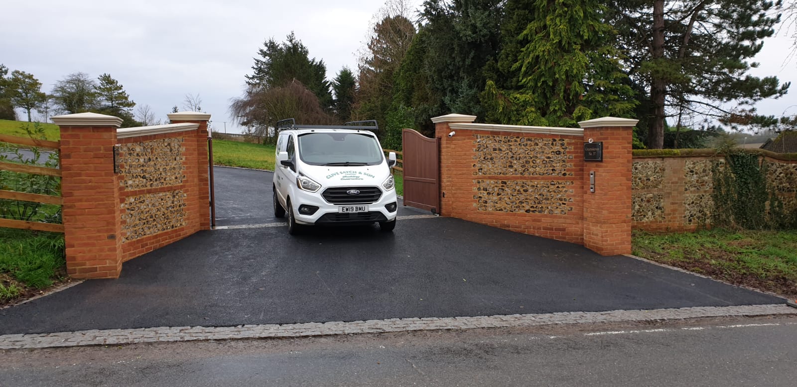 Brick and flint entrance wall with newly laid driveway