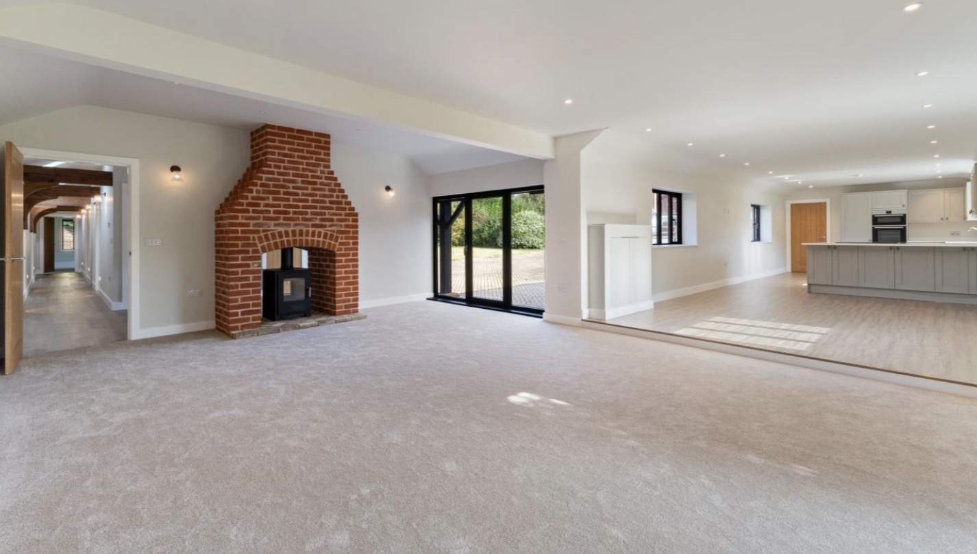 Open-plan living room with brick fireplace in converted barn